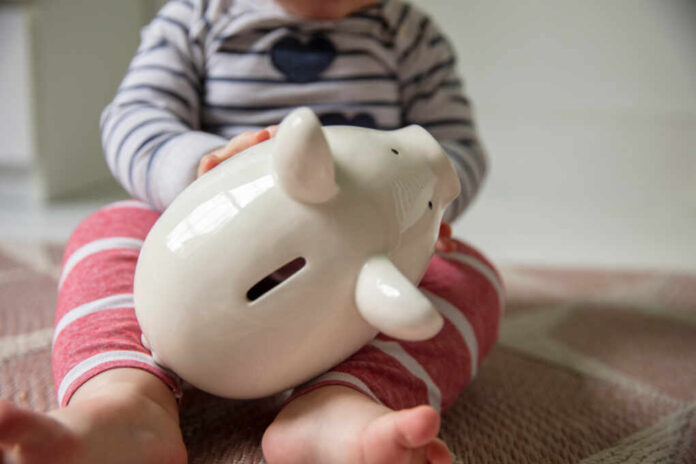 Cost,Of,Childcare,Concept.,Young,Baby,Holds,Onto,A,White