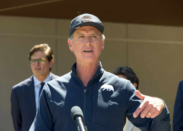 A man speaking at a press conference outdoors with a microphone