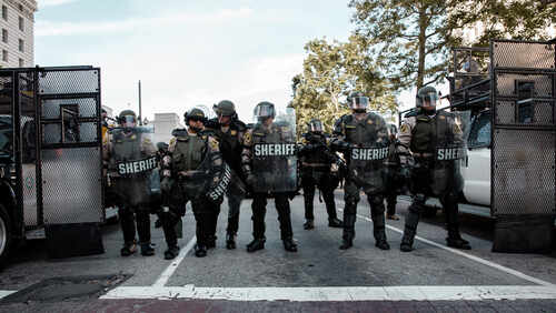 Law enforcement officers in riot gear standing in formation
