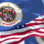 Minnesota state flag in front of American flags