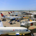 Airline CEOs Demand Action: Congress Slammed View of multiple Delta Airlines planes parked at an airport terminal with ground crew and vehicles
