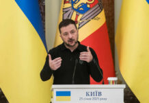 Ukrainian leader delivering a speech at a podium with national flags in the background