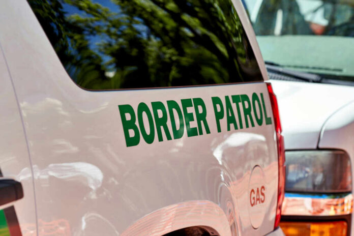 shutterstock_1135743830.jpg Close-up of a border patrol vehicle with green lettering