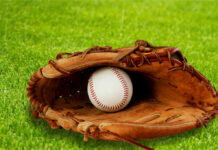 109-Year-Old Veteran Stuns Orioles Fans A baseball glove with a baseball resting inside, set on green grass
