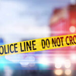 Yellow police tape reading DO NOT CROSS at a crime scene