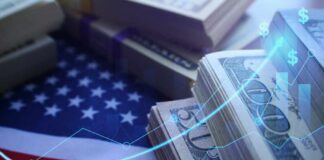 Stacks of US dollar bills on an American flag with financial graphs overlay
