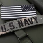 U.S. Navy patch and American flag on a green military surface