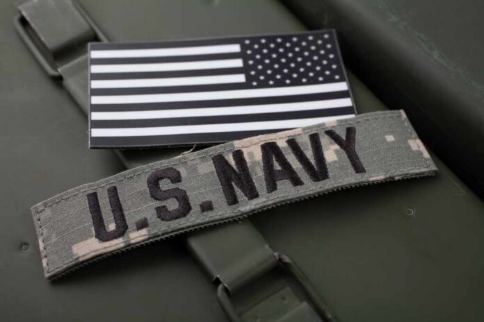 U.S. Navy patch and American flag on a green military surface