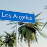 Sign indicating Los Angeles with palm trees in the background