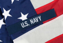 Submarine Nightmare: $8 Billion Delay Bombshell Close-up of the U.S. Navy insignia on an American flag