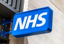 Crisis Hits UK 999 System As Workers Leave NHS sign displayed prominently on a building