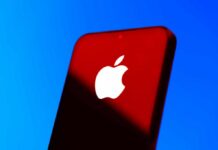 Apple’s $400M Move Shakes Up U.S. Jobs Close-up of a smartphone with the Apple logo against a red and blue background
