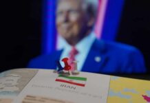 Map of Iran with push pins and a blurred figure in the background