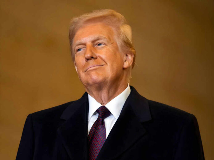 A man in formal attire smiling confidently against a neutral background