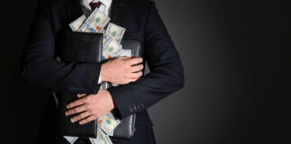 Businessman holding a briefcase filled with cash