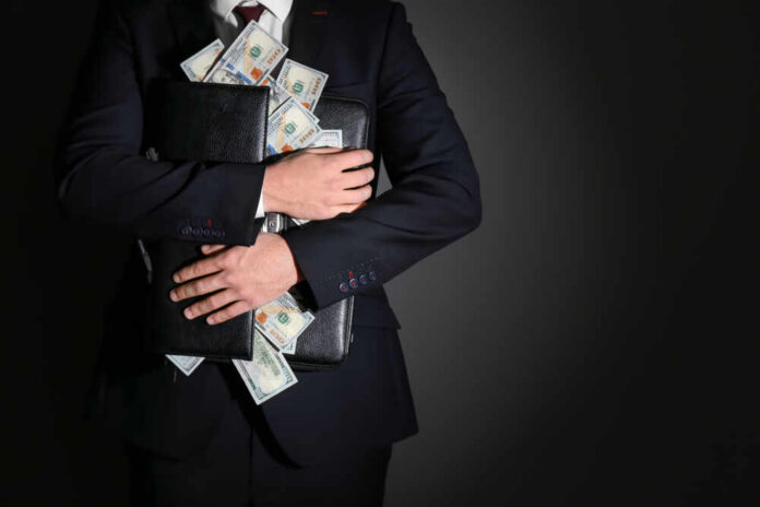 Businessman holding a briefcase filled with cash