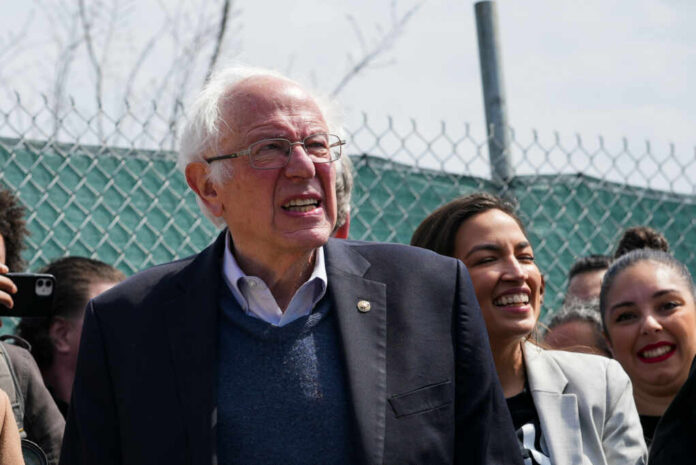 shutterstock_2149182565.jpg A group of people at an outdoor political rally, with a smiling man speaking and a woman laughing in the foreground