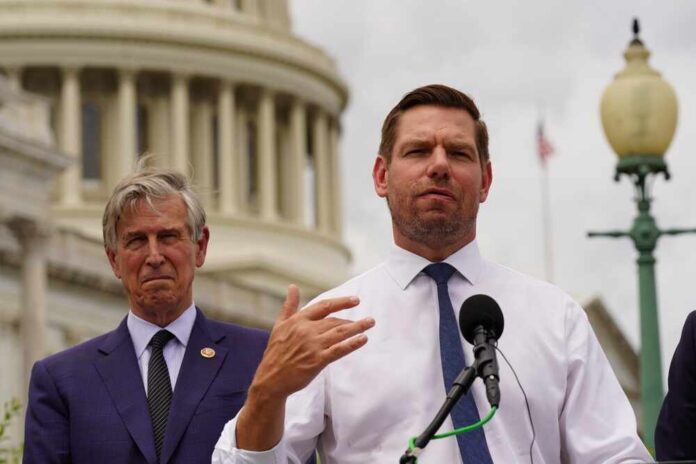 Two men at a press conference outside the Capitol building, one speaking into a microphone
