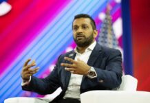 A speaker gesturing while discussing on stage at a conference