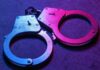 Army Veteran CHARGED: Top-Secret Unit Betrayed Close-up of metallic handcuffs illuminated with neon lights