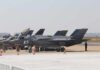 F-35 military jets parked on an airfield with crew members nearby