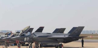 F-35 military jets parked on an airfield with crew members nearby