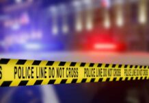 Yellow police tape reading 'DO NOT CROSS' at a crime scene