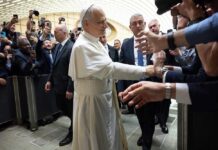Pope interacting with a crowd of people taking photos