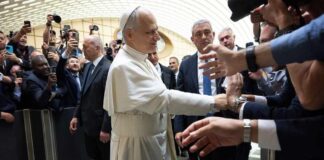 Pope interacting with a crowd of people taking photos