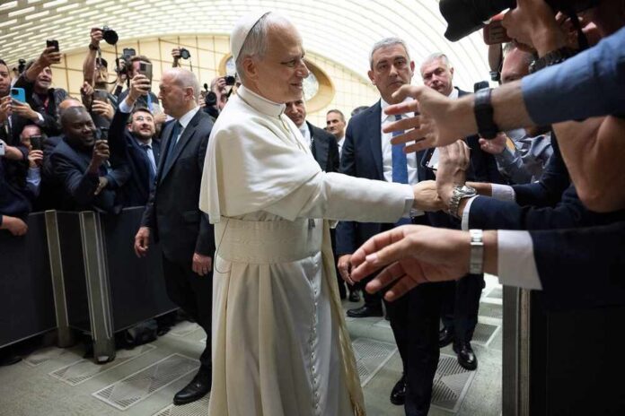 Pope interacting with a crowd of people taking photos