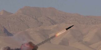 A missile launching into the sky with smoke and flames in a desert setting