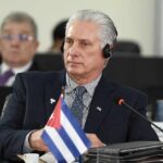Cuban leader at a political meeting wearing headphones