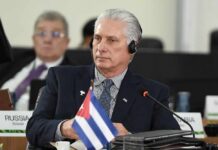 Cuban leader at a political meeting wearing headphones