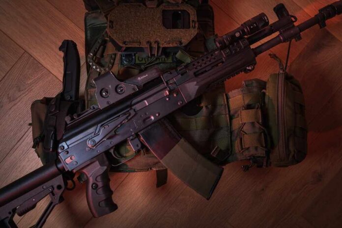 A tactical firearm placed on a military vest with accessories