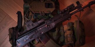 A tactical firearm placed on a military vest with accessories