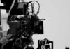 Close-up of a film camera with various cables and equipment in a studio setting