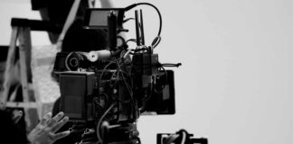 Close-up of a film camera with various cables and equipment in a studio setting
