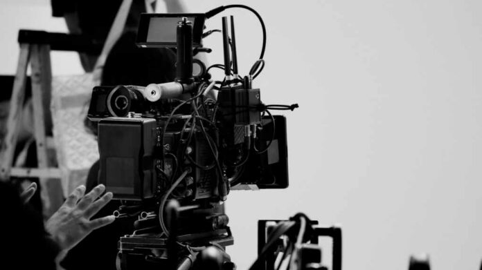 Close-up of a film camera with various cables and equipment in a studio setting
