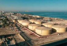 Aerial view of large oil storage tanks near a coastal area
