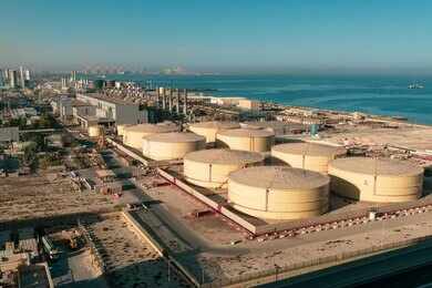 shutterstock_1859033734 Aerial view of large oil storage tanks near a coastal area
