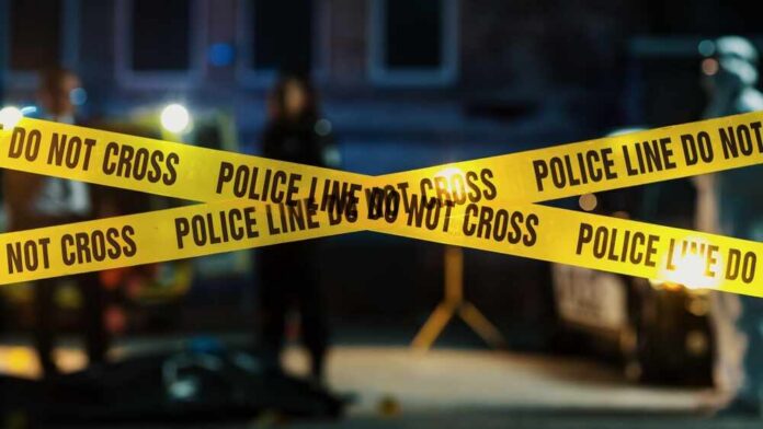 Restricted,Area:,Yellow,Tape,Showing,Text,"police,Line,Do,Not Police tape marking a crime scene with blurred figures in the background
