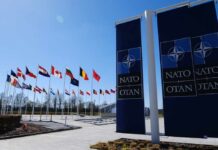 U.S. Troop Pullout: NATO Allies Alarmed Flags of various nations displayed outside NATO headquarters under a clear blue sky