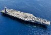 Record Deployment: Hidden Cost of USS Ford’s Mission An aircraft carrier with numerous fighter jets on its deck in the ocean