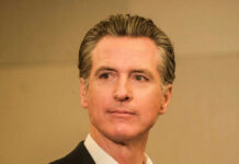 A man in business attire with a serious expression, captured in a medium shot
