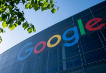 Google logo displayed on a glass building with green leaves in the foreground