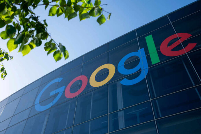 Google logo displayed on a glass building with green leaves in the foreground