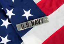 Navy’s Billion-Dollar Battleship Plan Sparks Debate Close-up of an American flag with a U.S. Navy insignia