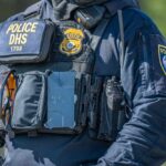 Police officer in tactical vest with equipment and radio
