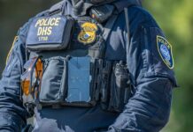 Police officer in tactical vest with equipment and radio