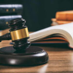 Judge's gavel on desk with open law book
